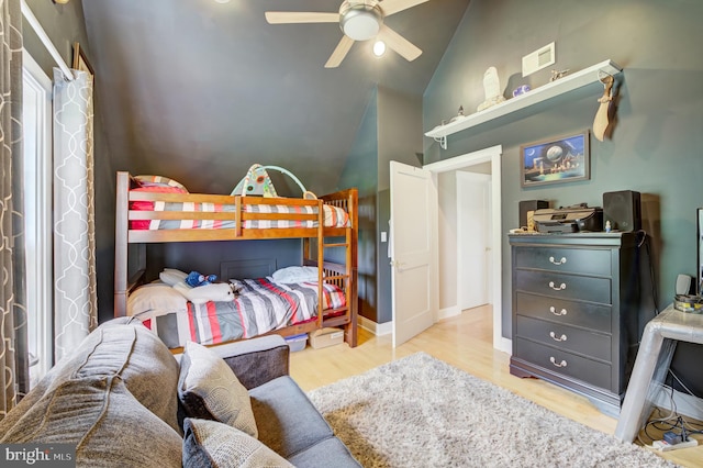 bedroom with ceiling fan, light wood-type flooring, and vaulted ceiling