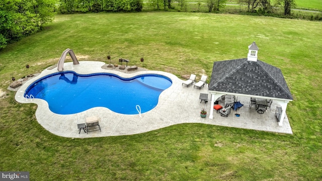 view of swimming pool featuring a lawn, a gazebo, a water slide, and a patio area