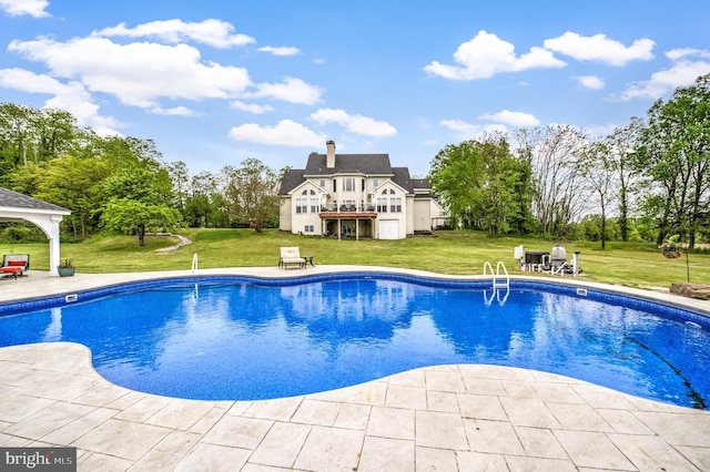 view of swimming pool featuring a patio and a yard