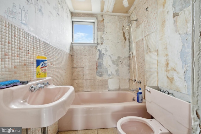 full bathroom featuring tile walls, sink, tiled shower / bath combo, and toilet