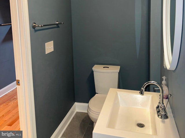 bathroom featuring hardwood / wood-style flooring, sink, and toilet