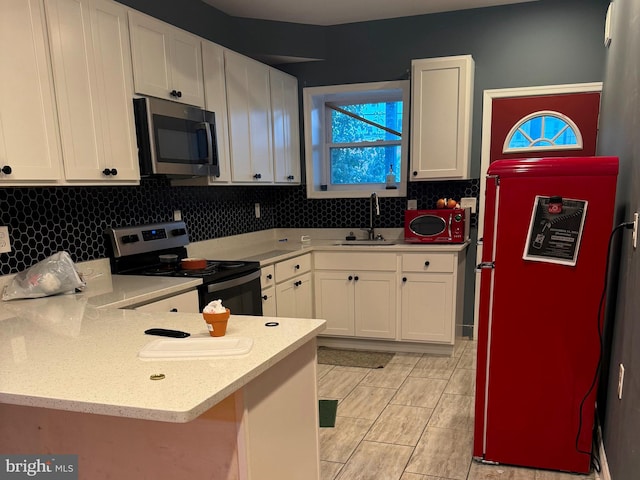 kitchen featuring white cabinets, appliances with stainless steel finishes, backsplash, and sink