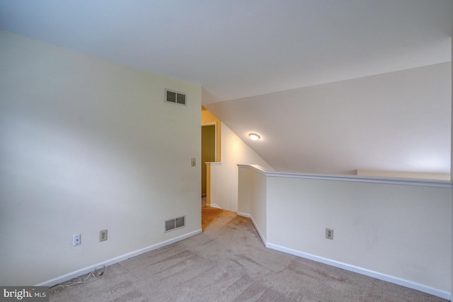 carpeted empty room with lofted ceiling