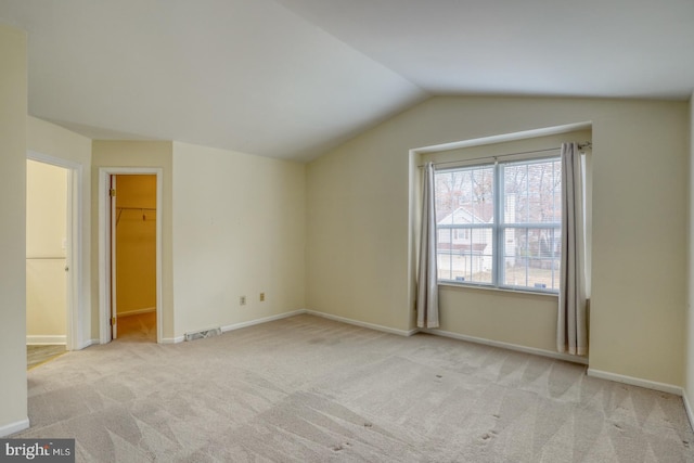 interior space featuring light carpet and vaulted ceiling