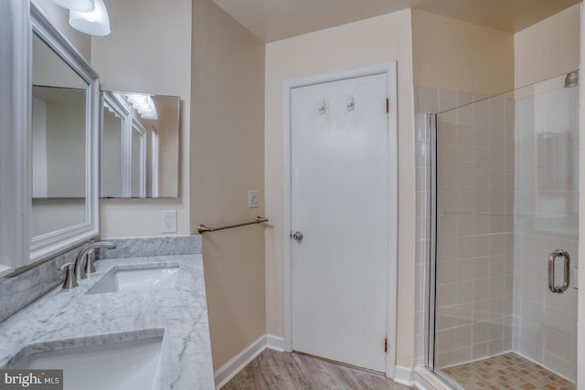 bathroom featuring wood-type flooring, vanity, and a shower with shower door