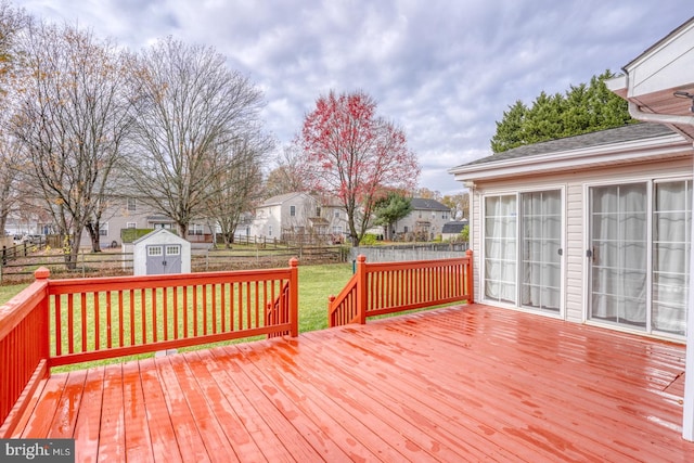 wooden deck with a yard and a storage unit