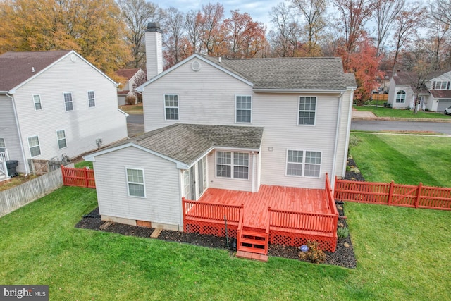 rear view of house featuring a deck and a yard