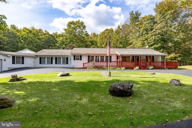 ranch-style home featuring a wooden deck and a front yard