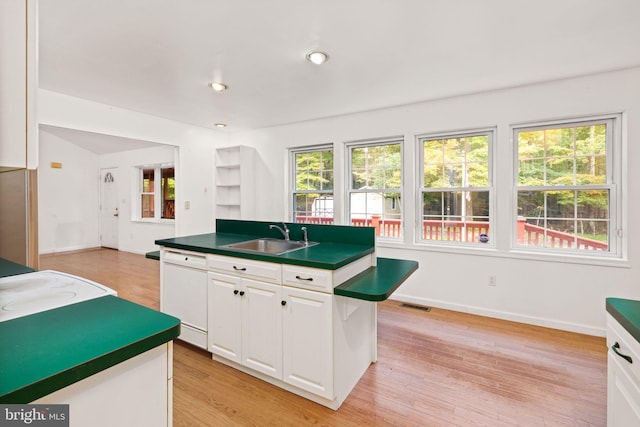 kitchen with an island with sink, white cabinets, and plenty of natural light