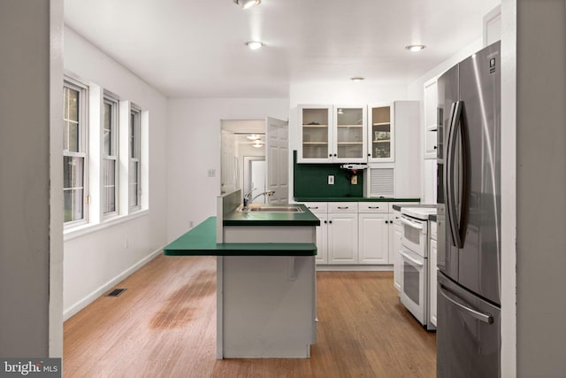 kitchen featuring stainless steel fridge, sink, white cabinetry, light wood-type flooring, and white range with electric stovetop