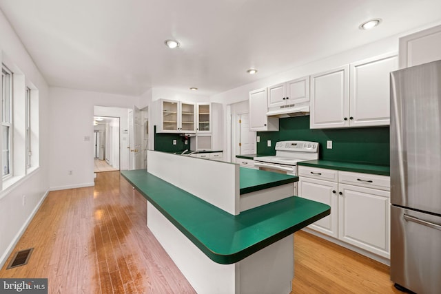 kitchen featuring white cabinetry, light hardwood / wood-style floors, white electric range oven, and stainless steel fridge