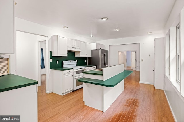 kitchen with white cabinets, white electric range oven, stainless steel refrigerator, a breakfast bar area, and light wood-type flooring