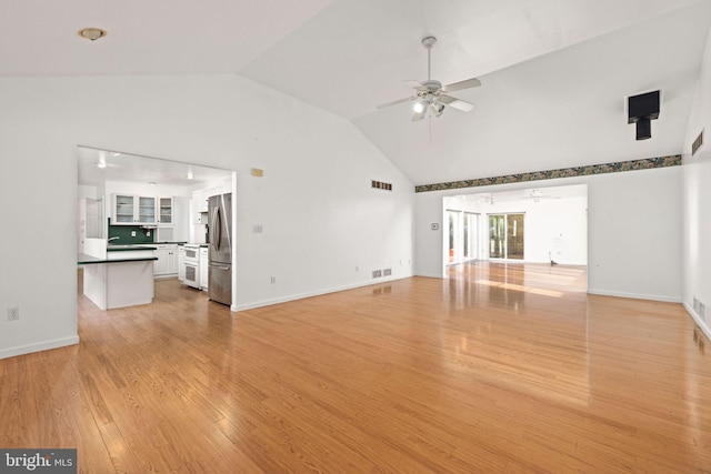 unfurnished living room featuring light wood-type flooring, lofted ceiling, and ceiling fan