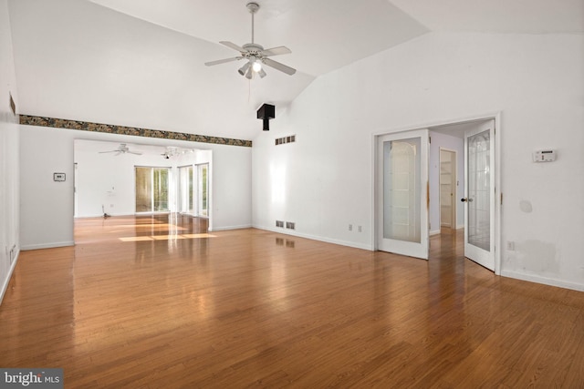 unfurnished living room featuring high vaulted ceiling, ceiling fan, hardwood / wood-style floors, and french doors