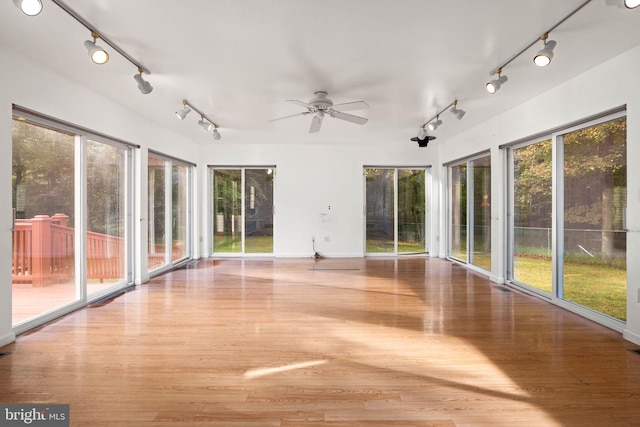 unfurnished sunroom featuring ceiling fan