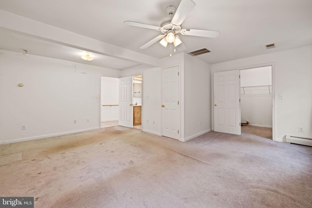 unfurnished bedroom with a spacious closet, a closet, ceiling fan, ensuite bathroom, and light colored carpet