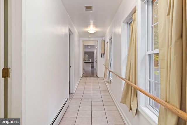 hall featuring a baseboard radiator and light tile patterned floors