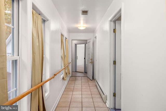 hall with a baseboard radiator and light tile patterned floors