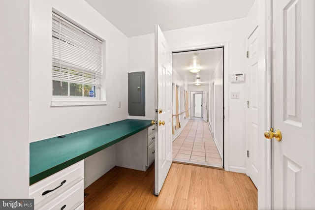 hallway with electric panel and light hardwood / wood-style flooring