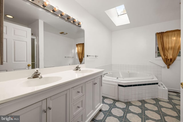 bathroom featuring tile patterned flooring, a skylight, tiled bath, and vanity