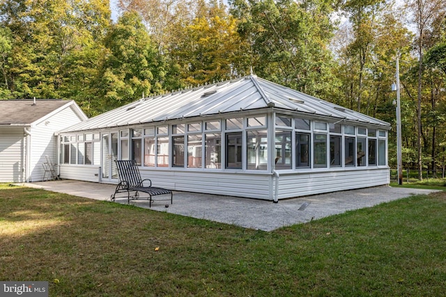 back of house featuring a sunroom, a yard, and a patio