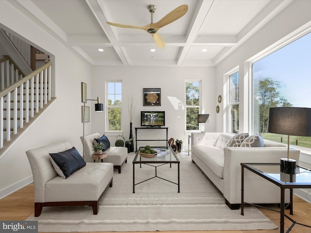 living room featuring ceiling fan, coffered ceiling, beam ceiling, and light hardwood / wood-style flooring