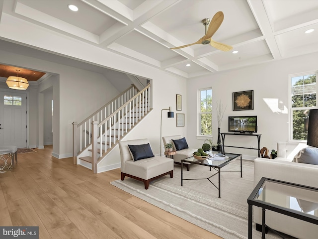 living room with coffered ceiling, ceiling fan, beamed ceiling, and light wood-type flooring