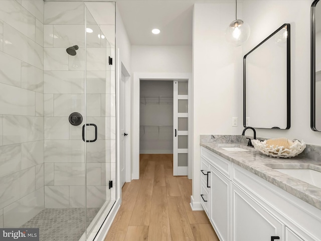 bathroom featuring vanity, wood-type flooring, and a shower with shower door