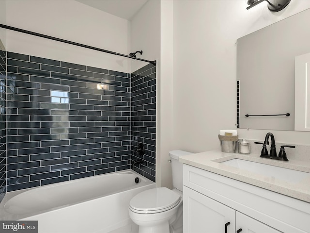 full bathroom featuring tiled shower / bath, vanity, and toilet