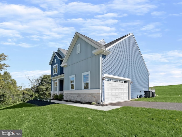 view of side of home featuring a garage, central AC, and a lawn