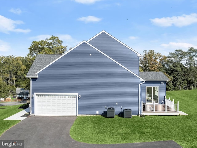 view of property exterior featuring a garage, central AC, covered porch, and a lawn