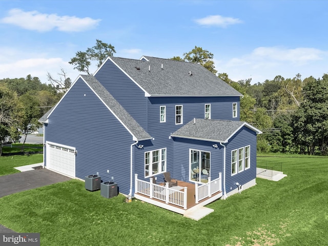 back of house featuring central AC unit, a garage, a lawn, and a porch