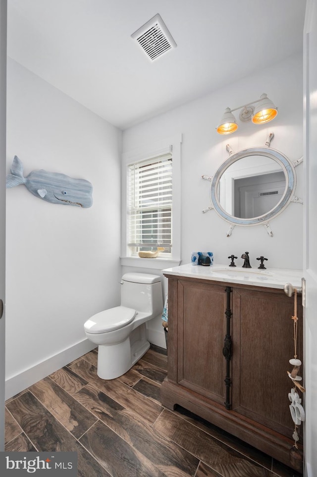 bathroom featuring toilet, hardwood / wood-style flooring, and vanity