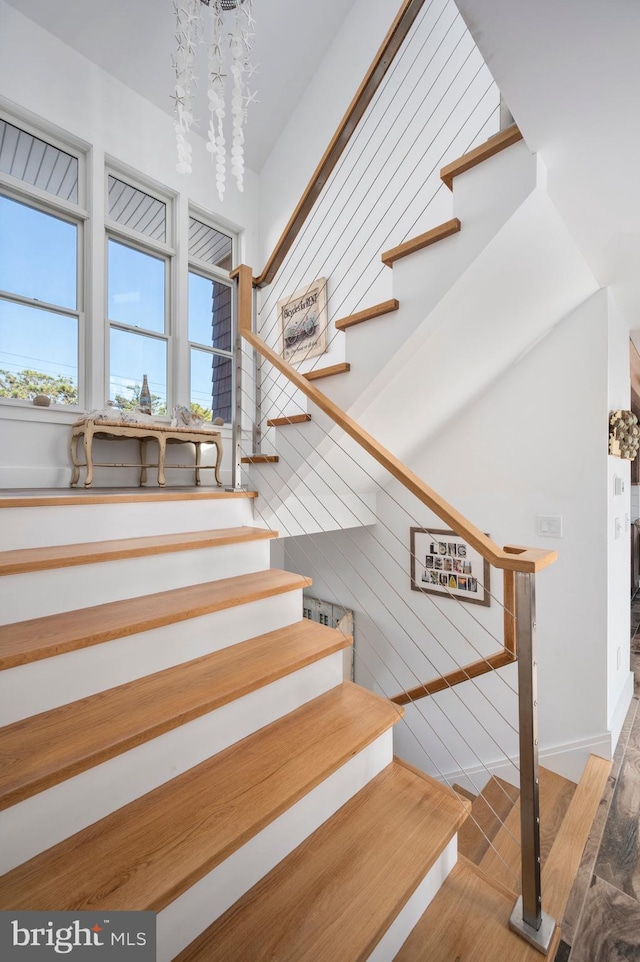 staircase featuring hardwood / wood-style flooring and a chandelier