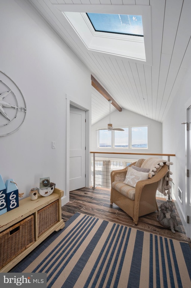 living area with vaulted ceiling with skylight, dark hardwood / wood-style floors, and ceiling fan