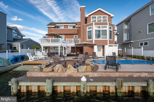 back of house with a patio area and a pool side deck with water view