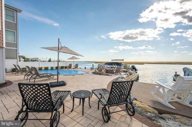 view of patio featuring a water view and a covered pool