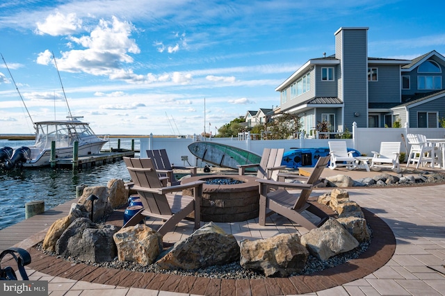 exterior space featuring a water view, a patio, and an outdoor fire pit