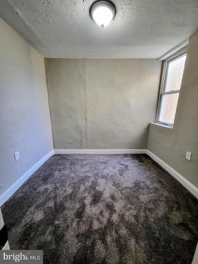 carpeted spare room with a textured ceiling