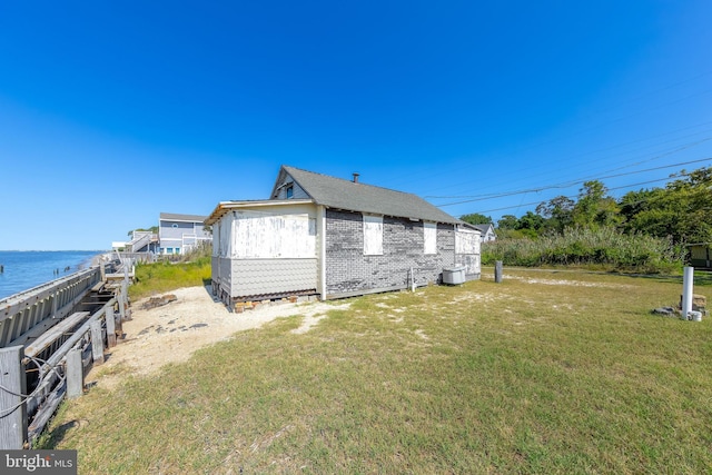 view of property exterior featuring a yard and a water view