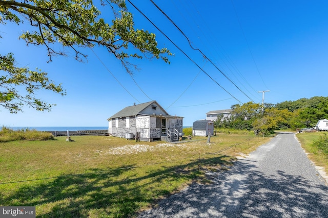 view of front facade featuring a front lawn and a water view