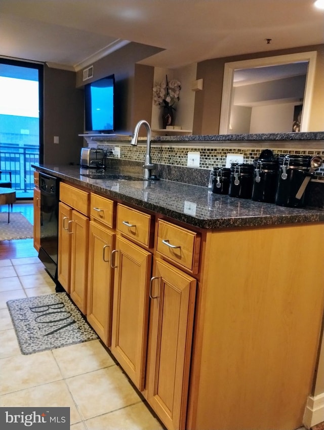 kitchen with dark stone counters, light tile patterned floors, sink, and black dishwasher