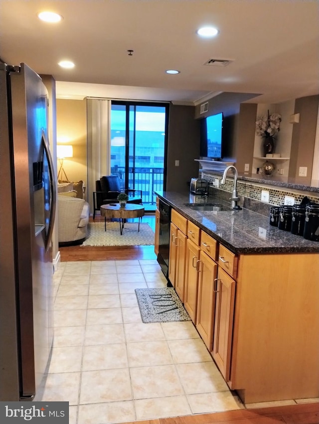 kitchen featuring stainless steel fridge, dark stone counters, light tile patterned floors, sink, and dishwasher