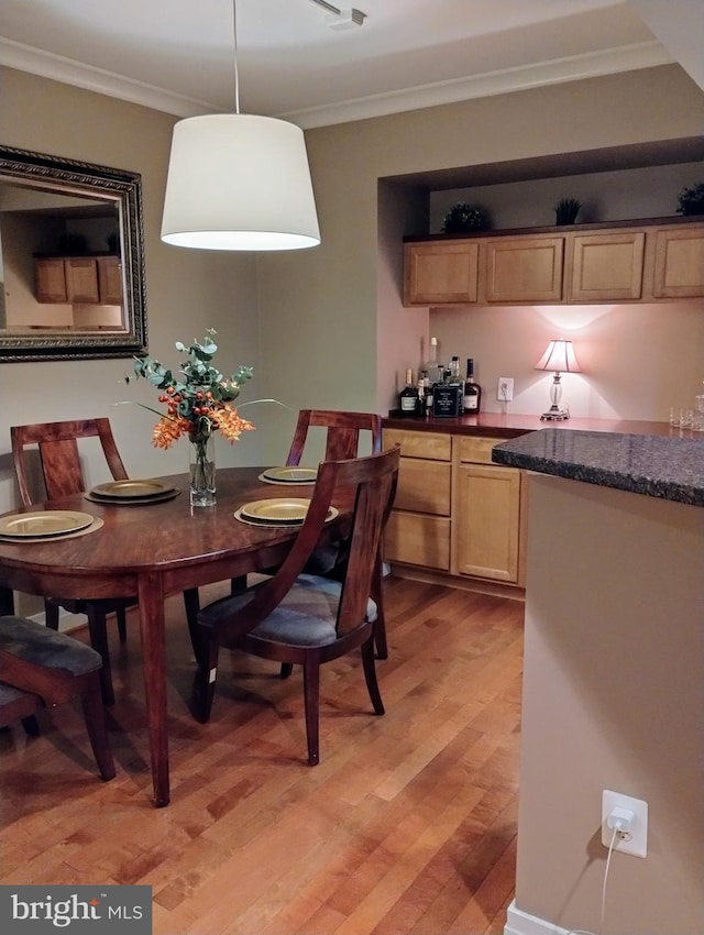 dining area featuring light hardwood / wood-style flooring and crown molding