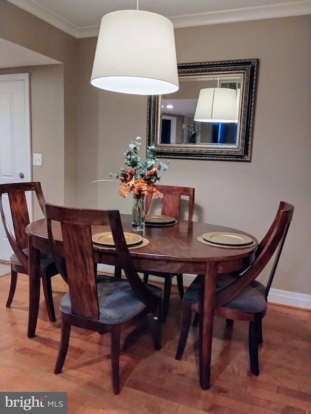 dining room featuring wood-type flooring and crown molding