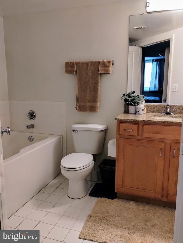 bathroom with tile patterned flooring, a bathtub, vanity, and toilet