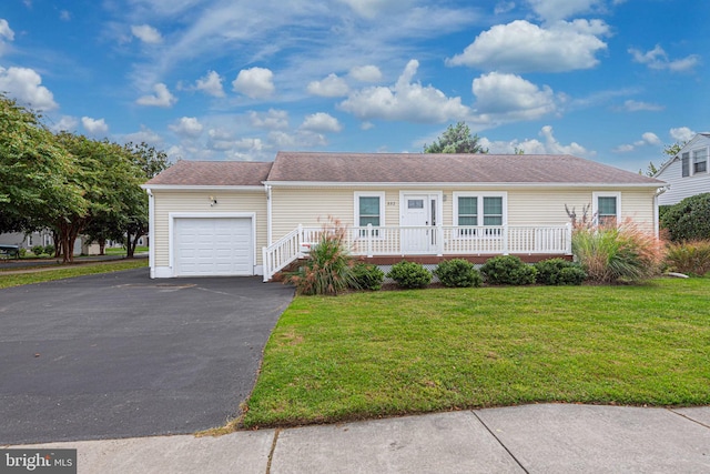 single story home featuring a porch, a garage, and a front yard