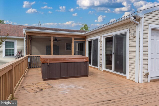 wooden terrace featuring ceiling fan and a hot tub