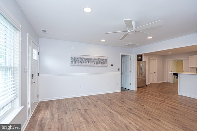 unfurnished living room featuring ceiling fan and hardwood / wood-style flooring