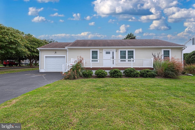 ranch-style home with a garage, covered porch, and a front lawn